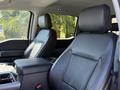 Interior view of a 2024 Ford F-550 Super Duty with black leather seats and a console between the front seats
