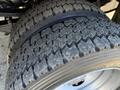 Close-up of the tread on a large tire from a 2009 Ford F-550 showcasing deep grooves designed for traction and durability