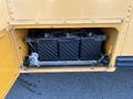 A 2007 Blue Bird Vision school bus with a compartment open, revealing three black batteries secured inside the bus's chassis