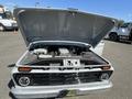 A 1962 Ford F-100 truck with its hood open displaying the engine compartment and various components inside