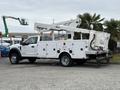 A 2018 Ford F-550 bucket truck featuring a white body and multiple storage compartments with an elevated platform for maintenance or utility work