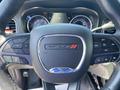 Close-up of a 2019 Dodge Charger steering wheel featuring the Dodge logo and various controls for audio and cruise settings
