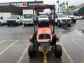A red 2010 Kubota F3680 lawn tractor with a canopy and large rear wheels facing forward