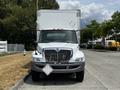 A 2019 International 4300 box truck with a white cab and large rear cargo area visible from the front angle