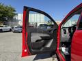 A red 2018 GMC Canyon with an open driver door showing the interior features and dashboard
