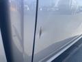 A silver 2021 RAM 1500 with a noticeable dent and paint damage on the driver's side door