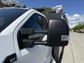 A 2023 Ford F-550 side mirror with a black casing showing details of its reflective glass and marker light