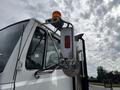 A 1998 Freightliner FL80 truck with a white cab and a side mirror featuring an orange light and reflectors