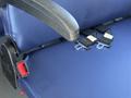 A close-up of a blue seat in a 2020 Chevrolet Express showing seat belt buckles and a red connector on the side of the seat