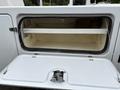A white 2018 Ford F-550 with an open compartment door revealing an empty storage space inside