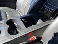 A center console in a 2013 Lincoln MKT featuring two cup holders and an empty storage compartment