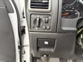 The image shows the control panel inside a 2012 GMC Canyon with dials for lights and a button for the parking brake