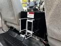 A metal cup holder mounted on a black box inside a 2009 Ford F-550's cabin