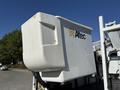 A white bucket truck with an Altec logo and an extended platform, part of a 2010 International 4300 model used for utility work