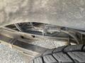 Close-up view of the undercarriage components of a 2023 GMC Savana showcasing the suspension and tire details