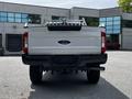 A 2017 Ford F-250 Super Duty truck viewed from the back with a white body and black exhaust pipe