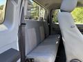 Interior view of a 2016 Ford F-550 showing the back seat area with gray fabric upholstery and seatbelts