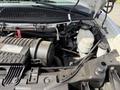View of the engine compartment of a 2020 Chevrolet Express showing the engine block and various components including hoses and fluid reservoirs