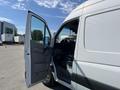 A 2010 Mercedes-Benz Sprinter van with the driver's side door open showing the interior and steering wheel