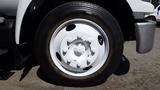 A close-up view of a white wheel with a central hub and multiple bolts on a tire, part of a 2006 Ford F-650 truck