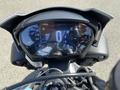 A close-up view of the dashboard of a 2018 Triumph Street Triple RS showing a digital display with speed and temperature readings