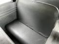 The interior of a 2015 Spartan School Bus featuring a gray vinyl bench seat with a textured surface and metal seatbelt buckles