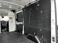 Interior of a 2021 Ford Transit van showing a spacious area with a black panel surface and minimal furnishings