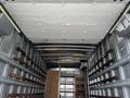 Interior of a 2018 Hino 195 truck with metal walls and wooden supports for cargo and a wooden partition at the back