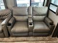 A pair of recliner seats in a soft gray upholstery with built-in cup holders on each armrest