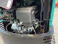 A 2024 AGT Industrial Green QH13R Mini Excavator showcasing its engine compartment with a black engine cover and various mechanical components visible inside