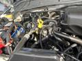 Engine compartment of a 2014 Ford F-350 SD showing various components including hoses batteries and wiring