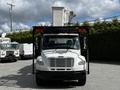 A 2012 Freightliner M2 106 truck with a white exterior and a bucket lift attachment on top facing forward