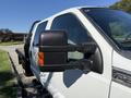 A white 2012 Ford F-350 SD with a large side mirror featuring an orange signal light