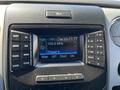 Dashboard of a 2014 Ford F-150 featuring a digital display showing radio information and controls for various audio functions