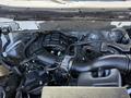Engine compartment of a 2014 Ford F-150 featuring various components including the air intake manifold hoses and electrical connections