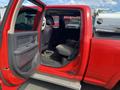 Red 2012 RAM 2500 truck door open revealing the interior with a single front seat and a spacious rear seating area