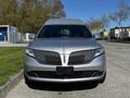 A silver 2013 Lincoln MKT with a distinctive front grille and sleek design facing forward
