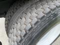 Close-up of a worn tire from a 2004 Ford F-750 showcasing a detailed tread pattern with visible dirt and wear marks