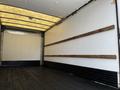Interior of a 2016 Isuzu NQR truck with wooden rails along the walls and a dark wooden floor