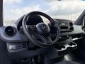 Interior of a 2021 Mercedes-Benz Sprinter showcasing the steering wheel dashboard and center console with cup holders