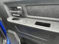 The interior door panel of a 2019 RAM 1500 Classic featuring a textured black surface and controls for windows and locks