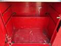 A red empty storage compartment with metal walls and no visible contents