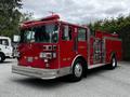 A red 1991 Sutphen Deluge fire truck with multiple lights and a shiny silver bumper features a compartment for equipment and the designation Engine 11 on the side