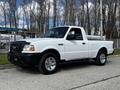 A white 2010 Ford Ranger pickup truck with a black grille and chrome wheels parked on a concrete surface