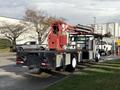 A 2010 International 4300 flatbed truck with a red crane attached to the rear