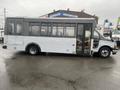 A 2017 Chevrolet Express shuttle bus in light blue with large windows and a wheelchair access ramp on the side