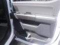 Interior door panel of a 2022 Ford F-150 featuring a sleek design with storage compartments and a soft touch surface