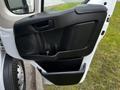 The door panel of a 2018 RAM Promaster featuring a black plastic design with an integrated handle and speaker area along with a storage compartment at the bottom