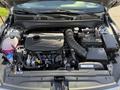 2024 Kia Forte5 engine bay showcasing the turbocharged engine with various components including the air intake and battery