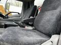 Interior view of a 2019 Hino 195 showing two gray patterned seats with armrests and a gear shift between them
